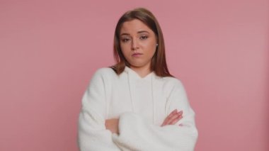 Mutsuz genç bir kadın nahoş berbat bir fikre tepki veriyor, kötü kaliteden memnun değil, el sallıyor, başını sallıyor hayır, reddet fikri, evlenme teklifini sevme. Pembe stüdyo arka planında yalnız bir kız.