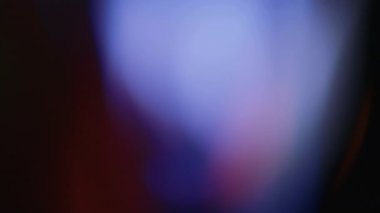 Çok renkli ışık siyah arkaplanda 4K görüntü sızdırıyor. Stüdyoda gaz sızıntısı var. Doğal aydınlatma ışınları bokeh etkisi. Çekimlerinizi birleştirmek, videoyu biçimlendirmek, geçişlerinizi