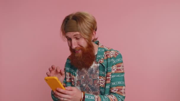 Szczęśliwy Podekscytowany Hippie Człowiek Koszuli Wzór Używać Telefonu Komórkowego Wpisując — Wideo stockowe