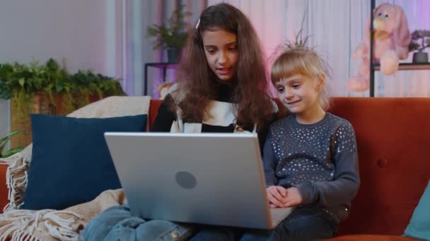 在完成教育工作后 小妹妹们的孩子们关闭了笔记本电脑 兄弟姐妹的孩子或朋友在家里的房间在线学习 远程工作 电子学习 在笔记本电脑上浏览互联网 — 图库视频影像