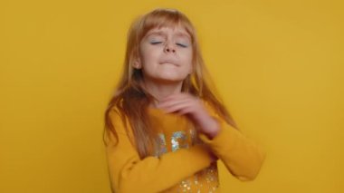 Neşeli, komik, genç, zorba çocuk. Dilini kameraya gösteriyor, dalga geçiyor, şakalaşıyor, aptal suratıyla maymunlaşıyor, alay ediyor. Sarı arka planda izole edilmiş küçük çocuklar.