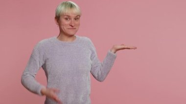 Kısa yeşil saçlı hoş bir kadın. Başparmaklarını gösterip boş bir yeri işaret ediyor. Ticari metinler için reklam alanı, ürün tanıtımı için kopya alanı. Pembe arka planda genç bir kız. Lgbt lezbiyen insanları