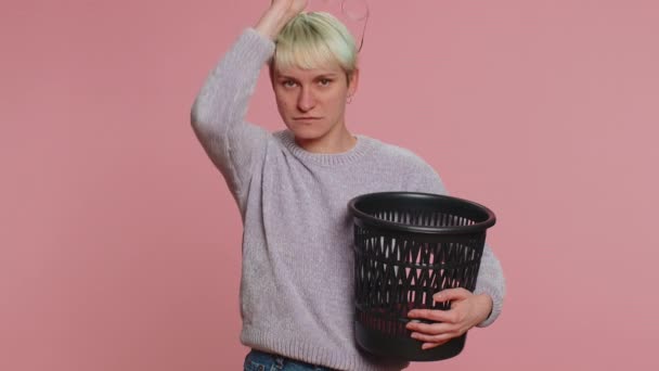 头发短的女人脱下来 把眼镜扔到后视镜激光治疗的垃圾桶里 微笑着看着相机 年轻姑娘被隔离在粉红工作室的背景下 Lgbt同性恋 — 图库视频影像