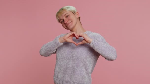 恋の女 短いブロンドの髪を持つ笑顔の女性は ハートジェスチャーは 愛のサインは良い感情や同情を表現します ピンクの背景に孤立した少女 Lgbtゲイのレズビアンの人々 — ストック動画