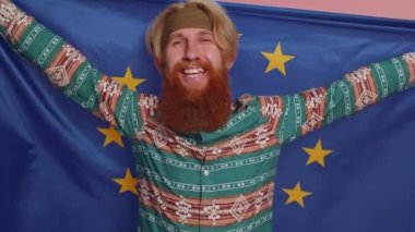 Avrupa Birliği bayrağı sallayan, gülümseyen, demokratik kanunlara tezahürat eden, Avrupa 'da insan hakları, özgürlükler. Kızıl saçlı hippi çocuk pembe stüdyoda izole edilmiş.