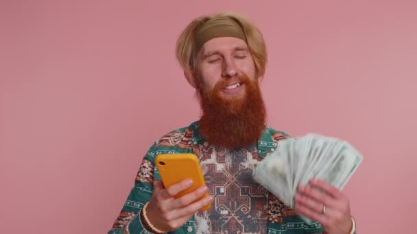 Boldog Hippi Turista Férfi Néz Smartphone Kijelző Őszintén Örvendezve Győzelem — Stock videók