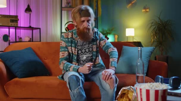 一个又一个的醉汉满头胡须的嬉皮士红头发的男人在家里用瓶子喝伏特加饮料 心情不好 无缘无故的爱情 酗酒成瘾 — 图库视频影像