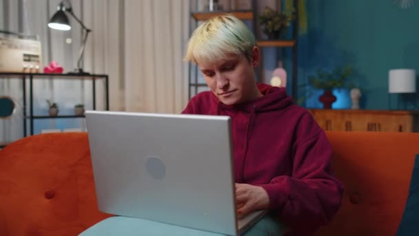 在家里沙发的客厅里完成工作后 坐在沙发上的短发女人关上笔记本电脑 女自由职业者在网上工作 远程工作 电子学习 在笔记本电脑上浏览互联网 — 图库视频影像