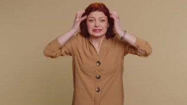 Genç kızıl saçlı kadın umutsuzluk, yalnızlık, sinir krizi, mağlubiyet piyango sonuçları, kötü talih, kayıp, şanssız haberler karşısında şaşırıyor. Beyaz kız stüdyo bej arka planda izole edilmiş.