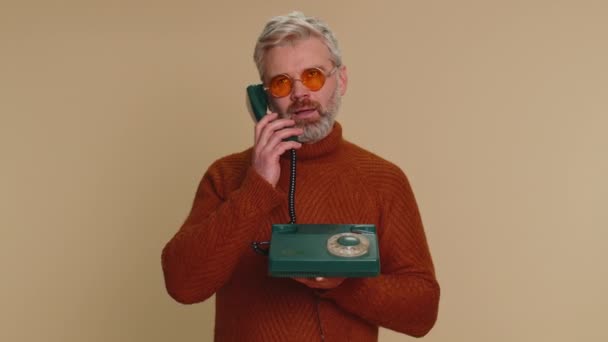 80年代の有線ヴィンテージの古い昔ながらの電話で話を 愚かな顔を コミュニケーションの話 不快感 興味深いことに興味がないだまされた疲れた中年の男性高齢者 シニア成熟した男 — ストック動画