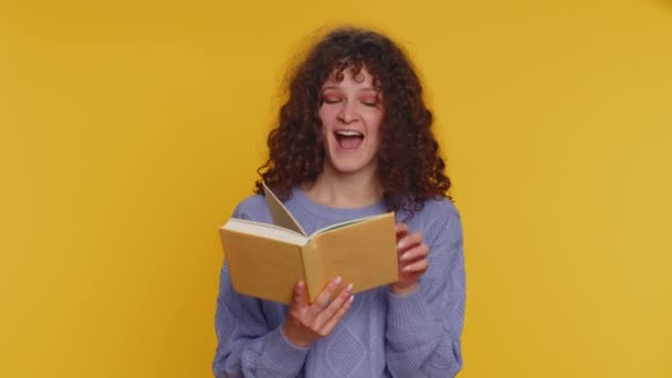 幸せな巻き毛の女性面白い面白いおとぎ話の本を読んで レジャー趣味 知識の知恵 すごい 若いですティーン女の子絶縁一人で黄色のスタジオの背景 — ストック動画