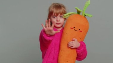 Young preteen child girl kid say No hold palm folded crossed hands in stop gesture, warning of finish, prohibited access, declining communication, danger. Little toddler children on gray background