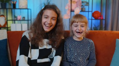 Mutlu ergen çocuk ve küçük kız kardeş saçma anekdotlar, komik şakalar duyduktan sonra kahkahalar atıyorlar. Kaygısız, neşeli ve pozitif hissediyorlar. Bayan kardeşler, çocuklar ya da oyun odasındaki en iyi arkadaşlar.