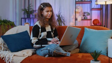 Kafkas ergen kız portresi dizüstü bilgisayarla tarama yapıyor, çalışıyor, kaybediyor aniden piyango sonuçları şaşırıyor, kötü haber, servet kaybı, başarısızlık. Küçük çocuk, çocuk evde kanepede oyun odasında