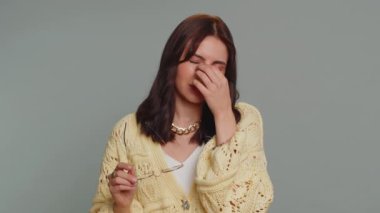 Exhausted tired pretty woman takes off glasses, feels eyes pain, being overwork burnout from long hours working, headache. Unhappy sad young adult girl isolated alone on gray studio background