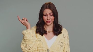 You are crazy, out of mind. Pretty young woman pointing at camera and showing stupid gesture blaming some idiot for insane plan, bullying. Millennial confused girl isolated on gray studio background