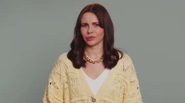 Displeased upset pretty woman reacting to unpleasant awful idea, dissatisfied with bad quality, wave hand, shake head No, dismiss idea, dont like proposal. Young girl on gray studio wall background
