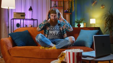 Aşırı neşeli, sakallı, kablosuz kulaklıklı genç adam koltukta oturup en sevilen disko müziği dinleyerek rahatlıyor. İnsanlar hafta sonu boş zaman aktiviteleri