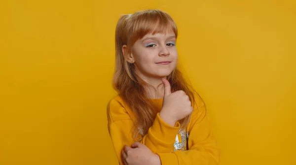 Great job, nice work. Young preteen child girl kid showing thumbs up and nodding in approval, successful good work, celebrate win, clapping hands. Little toddler children isolated on yellow background