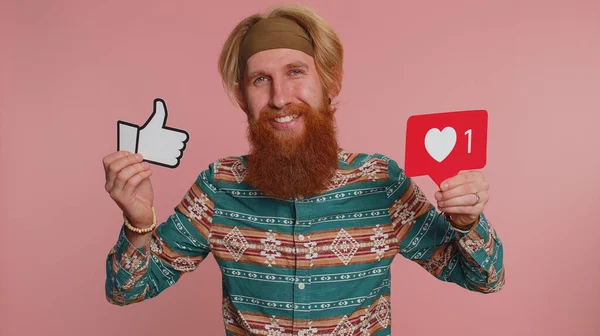 Like. Bearded redhead man in pattern shirt raises thumbs up banner logo agrees with something, gives positive reply recommends advertisement likes good. Young hippie guy on pink studio background
