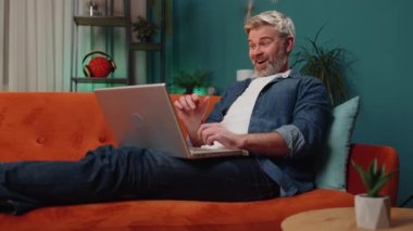 Oh my God Wow. Surprised mature man use laptop computer, receive good news message, shocked by sudden victory, celebrate win, lottery jackpot, purchases online shopping at home. Lifestyle technologies
