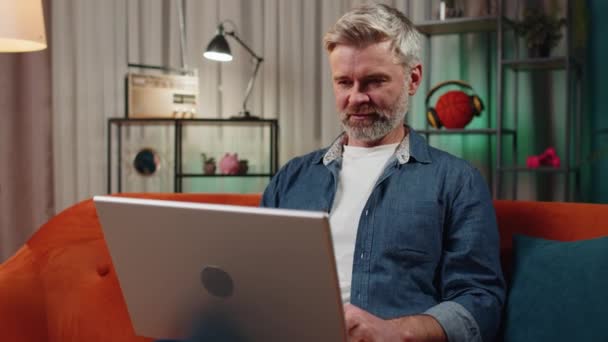 Бородатый Мужчина Сидит Диване Закрывает Ноутбук После Окончания Работы Гостиной — стоковое видео