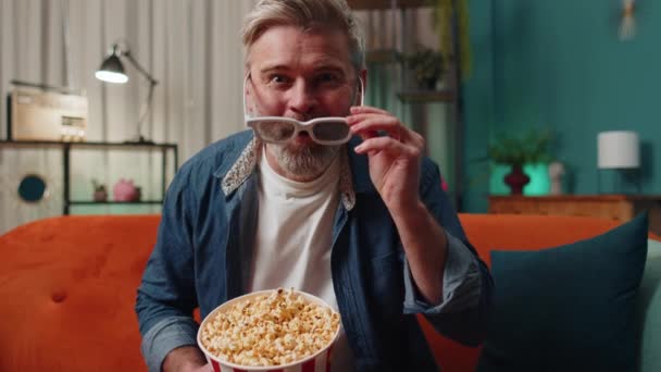 Excited Bearded Middle Aged Man Sits Sofa Eating Popcorn Snacks — Vídeo de Stock