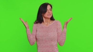 Excited amazed pretty woman in sweater touching head and showing explosion, looking worried and shocked, professional burnout. Looking surprised wow girl isolated alone on green chroma key background