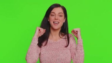 Funny joyful sincere woman 30 years old dancing, making playful silly facial expressions and grimacing, fooling around showing tongue. Young lovely pretty girl isolated alone on chroma key background