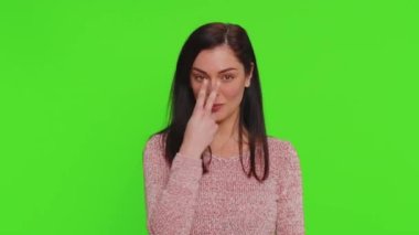 I am watching you. Caucasian woman in sweater pointing at her eyes and camera, show I am watching you gesture, spying on someone. Young adult pretty girl isolated alone on green chroma key background