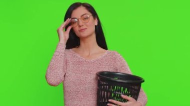 Lovely woman taking off, throwing out glasses into trash bin after medical vision laser treatment therapy surgery, looking smiling at camera. Young adult girl isolated alone on chroma key background