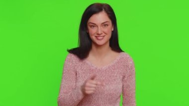 Hey you. I choose you. Young woman in sweater smiling excitedly and pointing finger to camera, choosing lucky winner, indicating to awesome you. Pretty girl indoors isolated on chroma key background