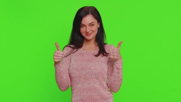 穿着毛衣的漂亮女人竖起大拇指同意某事或给予肯定的回答推荐广告喜欢好的 赞成的 孤身一人的小女孩 背景为绿色 — 图库视频影像