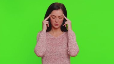 Hipster young pretty woman in sweater rubbing temples to cure headache problem, suffering from tension, migaine, stress, grimacing in pain, high blood pressure isolated alone on red wall background