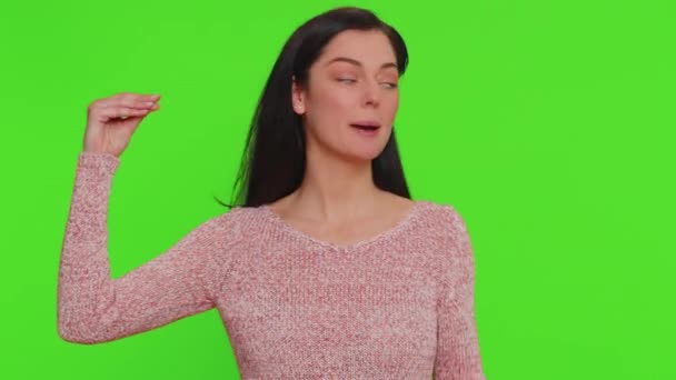 セーターの手で何とかジェスチャーを示すかなり若い女性が退屈し ゴシップ 空の約束 以前に興味を持っていない 緑のクロマキーの背景に隔離された千年の少女 — ストック動画