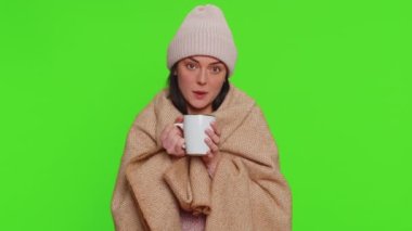 Sick woman wear hat wrapped in plaid shivering from cold, drinking hot tea in unheated apartment without heating due debt. Unhealthy girl feeling discomfort try to warming up on chroma key background