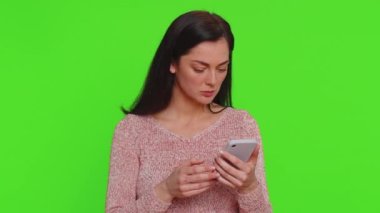 Pretty woman playing on smartphone typing browsing, loses becoming surprised sudden lottery results, bad fortune, loss, game fail, bankruptcy. Young girl isolated alone on green chroma key background