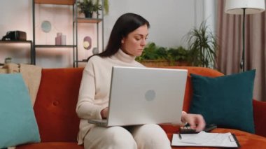 Woman accountant working with documents graph, calculate taxes for charts and graph reports of home income. Businesswoman working on laptop computer with financial bills planning expenses budget