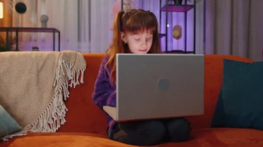 Portrait of caucasian toddler girl use laptop typing browsing working, loses becoming surprised sudden lottery results, bad news, fortune loss, fail. Teen child kid at home in play room on couch