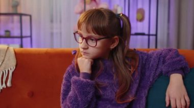 Sad lonely toddler girl at home looks pensive thinks over life concerns or unrequited love, suffers from unfair situation. Teen child, kid problem, break up, depressed feeling bad annoyed burnout