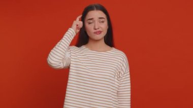 I dont know what to say. Confused woman feeling embarrassed about ambiguous question, having doubts, no idea, being clueless and uncertain. Young pretty girl isolated on red studio wall background