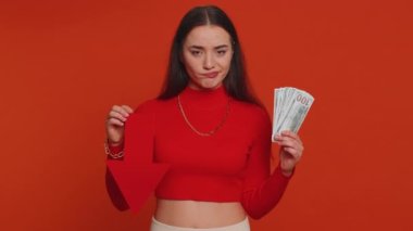 Upset pretty woman showing red arrow pointing down, concept of downgrade, unsuccessful business, fall of stock market money dollar exchange rate bankruptcy fail. Young adult girl on red background
