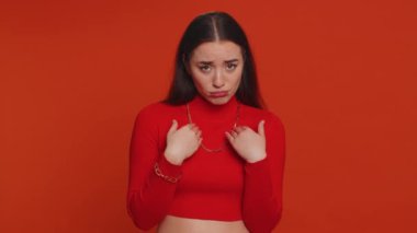 Give me money, please. Woman rubbing fingers show cash gesture, demands to pay back the debt, take loan, do shopping, begging, investment, reward. Young adult girl isolated on red studio background