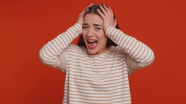 ストレス緊張の問題から悲鳴を上げるプルオーバーの若い女性は恐怖絶望恐怖驚きショックは怒りを表現しています かなりブルネット女の子屋内孤立した一人でスタジオ赤の背景 — ストック動画