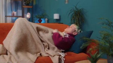 Repair work at neighbours. Irritated woman sleeping on couch cover ears with pillows annoyed by noisy neighbors suffer from headache wishes silence. Thin walls at home flat without sound insulation