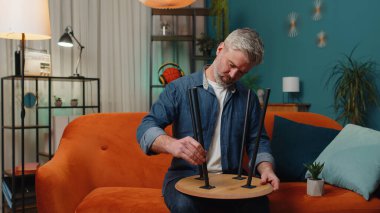Mutlu sakallı adam evde mobilya montajını bitiriyor. Başarılı masa tahsilatı, onarım, onarım. Yeni daireye taşındıktan sonra. Mobilya mağazasının reklamı. İpotek, yaşam tarzı