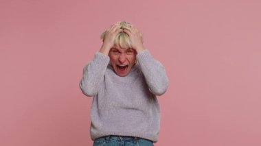 Woman with short green hair screams yell from stress tension problems feels horror hopelessness fear panic surprise shock expresses gestures rage. Girl on pink background. Lgbt gay lesbian people