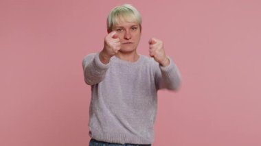 Angry aggressive woman showing fig negative gesture, you dont get it anyway. Rapacious, avaricious acquisitive. Body language. Refusal fig sign. Greedy girl on pink background. Lgbt gay lesbian people