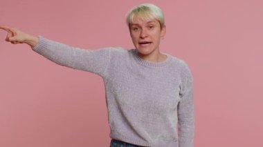 Get out of here. You are fired. Woman with short green hair pointing finger away asking to leave her alone, strict boss firing conflict. Young girl isolated on pink background. Lgbt gay lesbian people