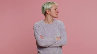 Offended millennial woman with short green hair having misunderstanding frustrated after quarrel, ignores and does not want to communicate, talk. Young girl on pink background. Lgbt gay lesbian people